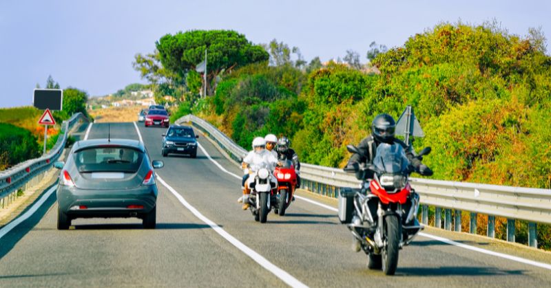 אופנועים ומכוניות על מדרון כביש אופנועים ומכוניות על מדרון כביש